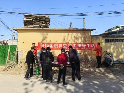 （图片说明：村民学习金融知识宣导手册）