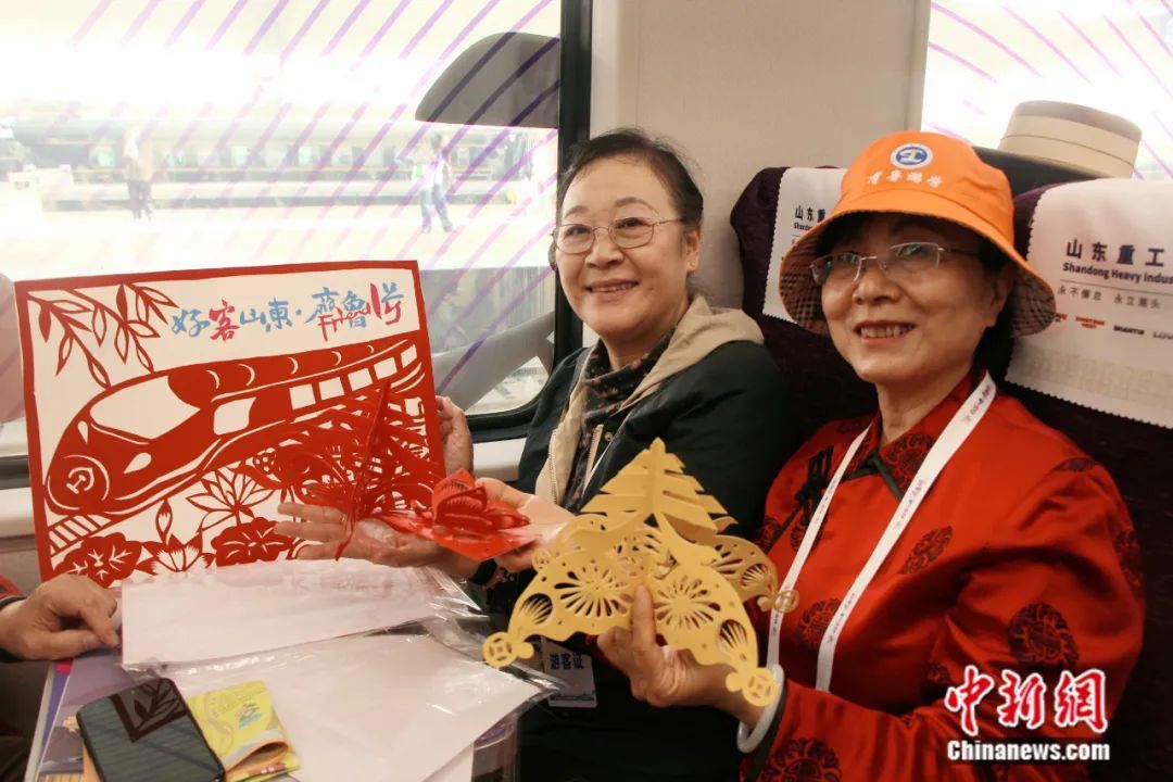 山东老年大学学员带着手工创作的剪纸作品乘车。赵晓 摄