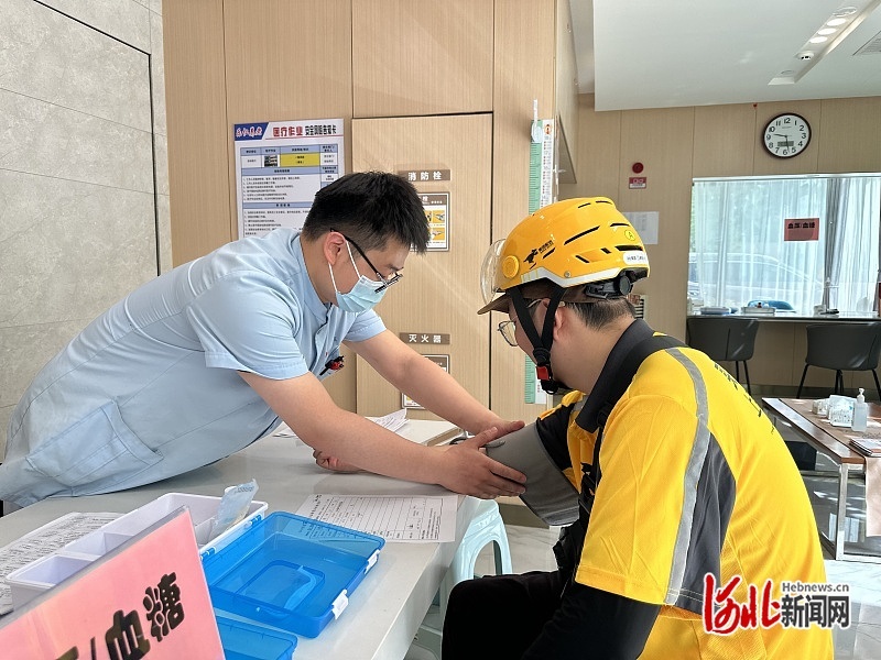 图为外卖骑手进行义诊体检。孔新花/摄
