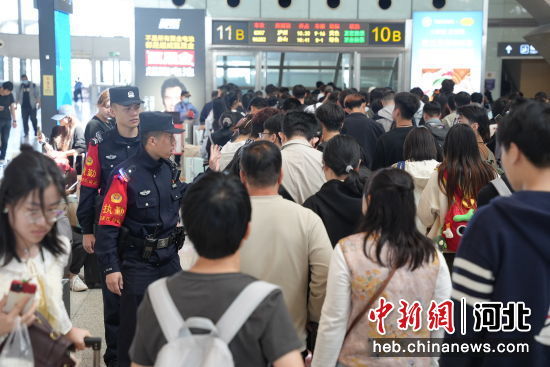 图为石家庄站派出所民警在候车室检票口答疑解惑。 左文宇 摄