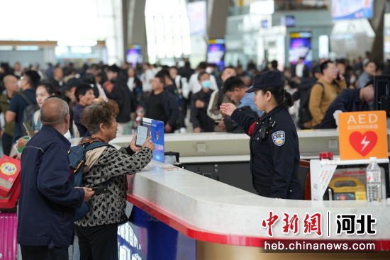 图为石家庄站派出所民警在候车室报警服务台为旅客答疑解惑。 左文宇 摄