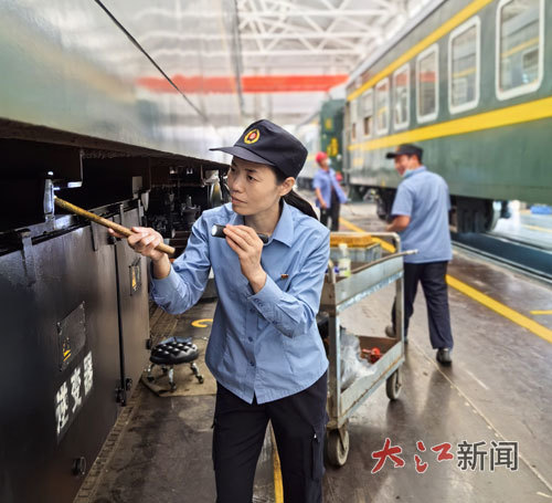 吴园梅在检修主库检查车下电源的悬吊螺杆是否紧固。本报全媒体记者陈化先摄