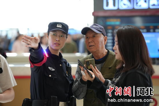 图为石家庄站派出所民警在候车室为旅客答疑解惑。 左文宇 摄