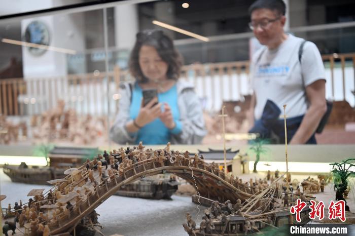 图为观众拿手机拍摄白牦牛角打造的立体版《清明上河图》　中新社记者　九美旦增　摄