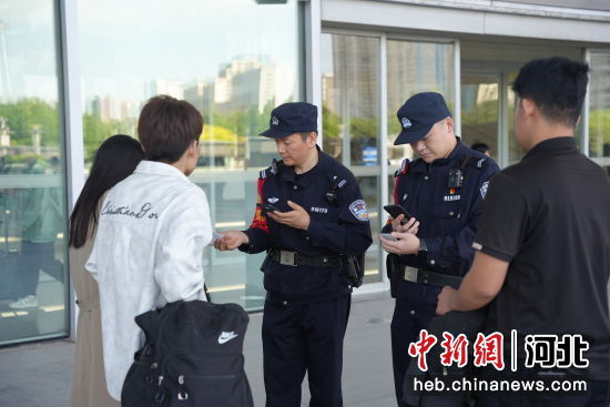 图为石家庄站派出所民警在西广场查验旅客身份证件。 左文宇 摄