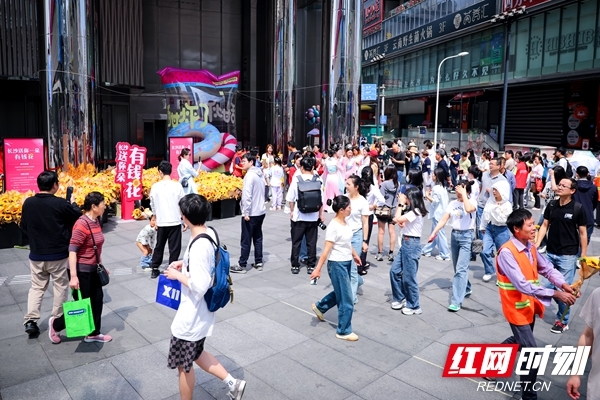 “长沙，送你一朵‘有钱花’”街头互动现场人头攒动，排起领花“长龙”。