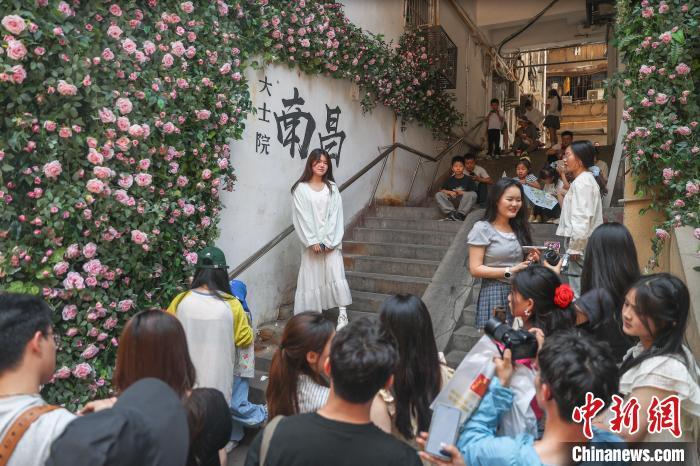 5月2日，江西南昌東湖區，游客在大士院老街的一處打卡墻前拍照。中新社記者 劉力鑫 攝