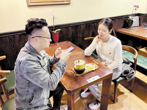 3月29日,在保定西大街翡冷翠咖啡馆里,来自北京的游客正在为摆放着迷你驴肉火烧的“驴火拿铁”拍照。本报记者 赵晓昕摄