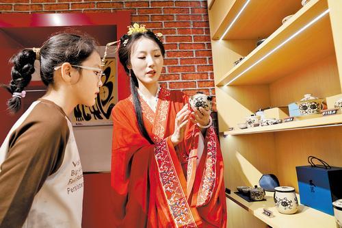 5月1日，邯郸成语之都&middot;文创旗舰店内，身穿战国袍的工作人员（右）为顾客介绍磁州窑茶具。 本报记者 陈正摄