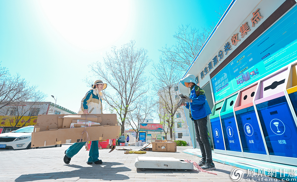 金川区宝星里社区居民秦霞(左)将初分类的垃圾送往环保小屋