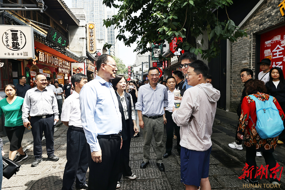 (毛伟明在太平老街与游客交流。)