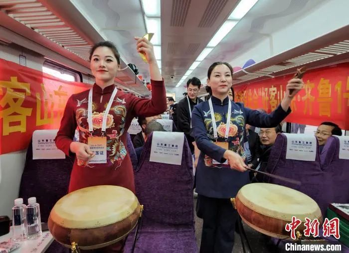 山东管理学院“琴声书韵曲艺社”老师和学生在列车上表演山东鼓曲联唱。赵晓 摄