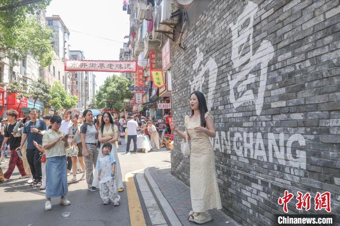 5月2日，江西南昌東湖區，游客在大士院老街的一處打卡墻前拍照。中新社記者 劉力鑫 攝