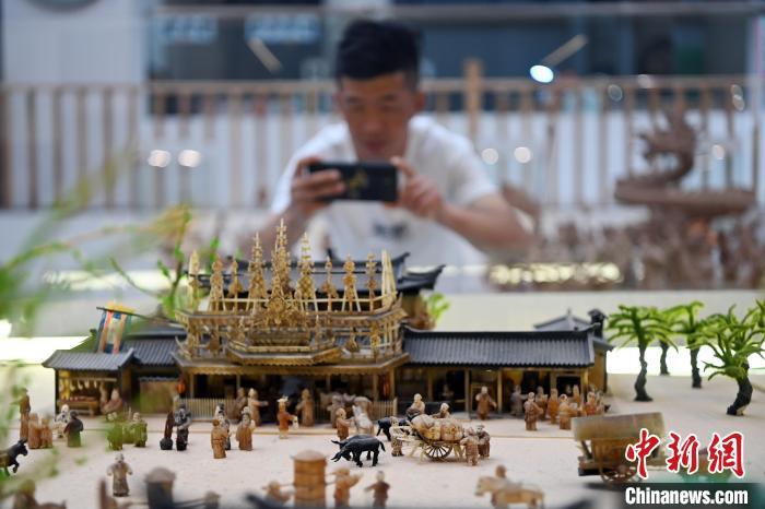 图为观众用手机拍摄白牦牛角打造的立体版《清明上河图》　中新社记者　九美旦增　摄