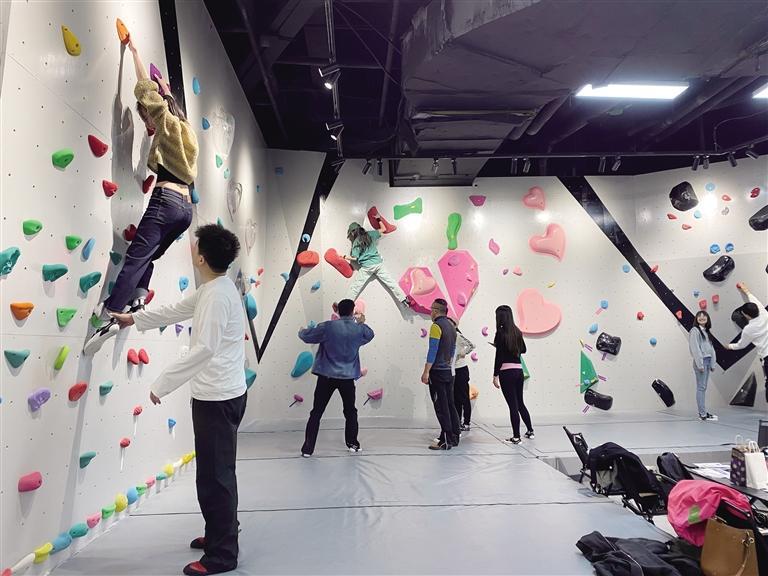 市民在教练的指导下尝试攀岩抱石运动