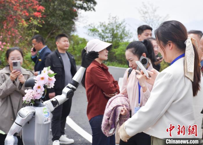 “五一”小长假,湖南双牌阳明山景区引入人形机器人与游客互动。(景区供图)