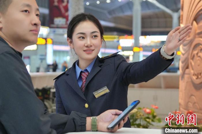 图为西安北站工作人员服务旅客。尤艇 摄