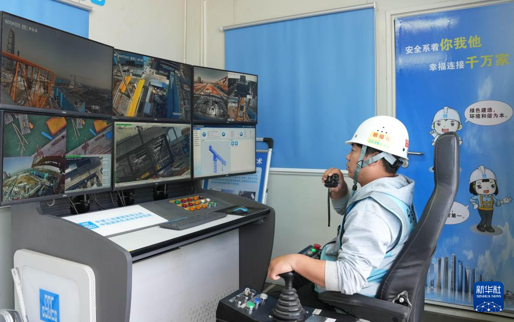 4月23日，在中国矿产雄安总部项目建设工地，塔吊司机在数字全景塔机集控驾驶舱内进行吊装作业。新华社记者 落飞麟 摄