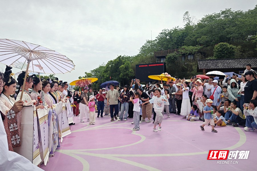 在矮寨奇观旅游区,十二花神巡游惊艳登场,身着华服的“花神”手持团扇,漫步云端天桥,与游客互动赠福袋。