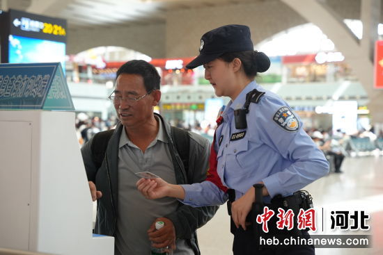 图为石家庄站派出所民警在候车室为旅客提供帮助。 左文宇 摄