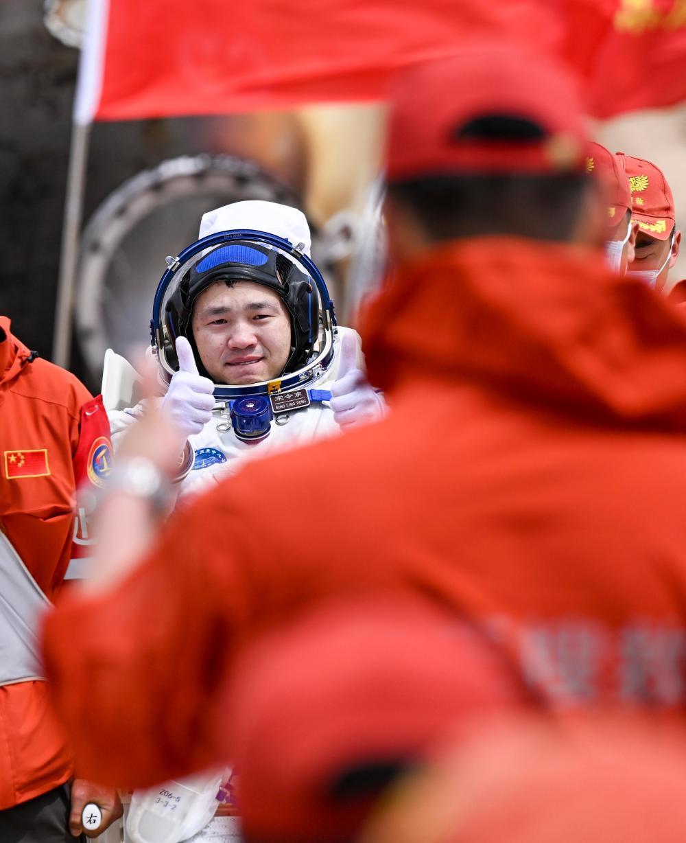 这是宋令东安全顺利出舱后，与工作人员相互致意。