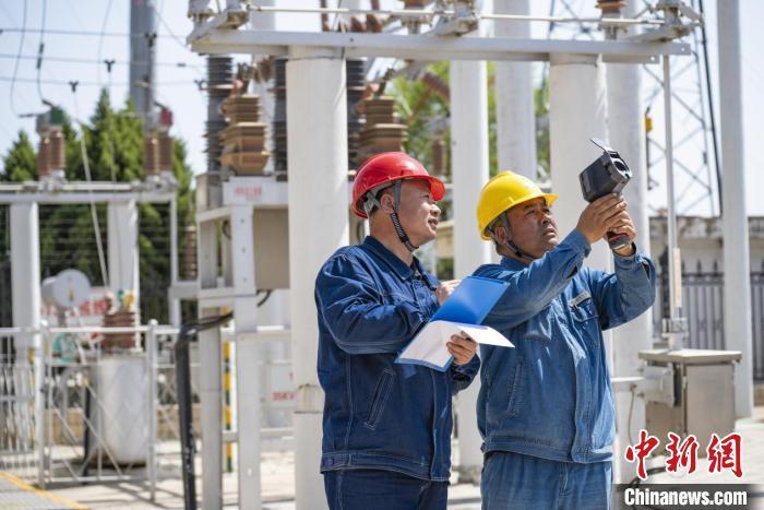 全国劳动模范何建功(左)与同事检测电力设备　陈高凤　摄