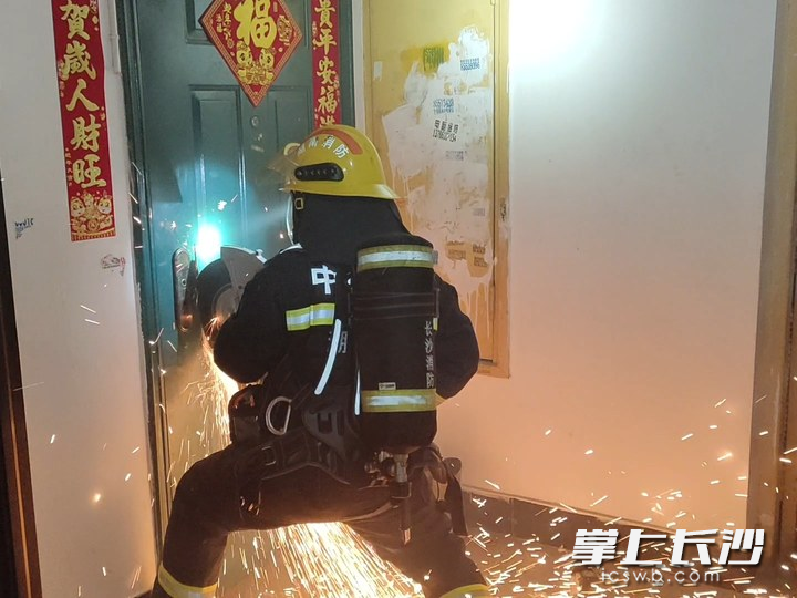 消防员破门救火。 长沙晚报通讯员 罗霜操 摄