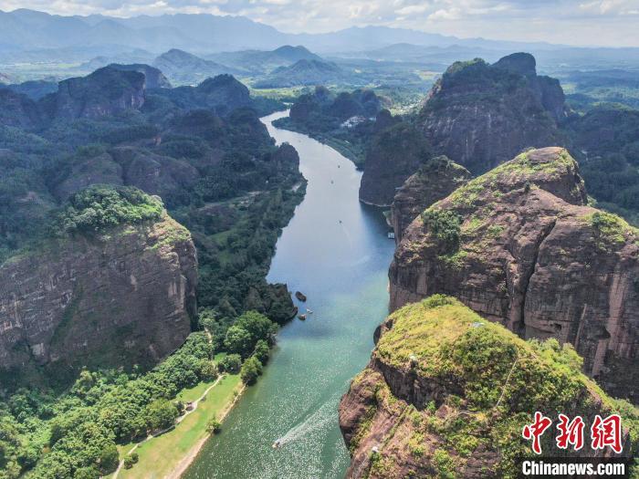 航拍江西龙虎山泸溪河两岸，水清岸绿，一座座丹霞地貌的山峰形状各异，一艘艘竹筏荡漾在碧波之上，风景秀美。刘力鑫 摄