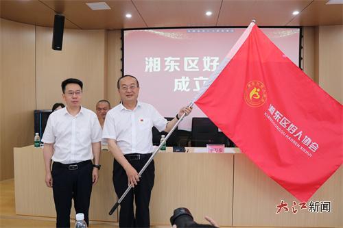 湘東區(qū)委常委、宣傳部部長李萬安（左）為協(xié)會授旗（葉斯妮 攝）