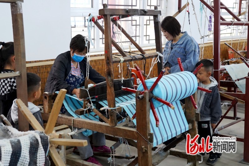 游客在迁安市高引铺村观看“绣娘”织布,感受非遗代表性项目手工织布技艺。韩春东摄