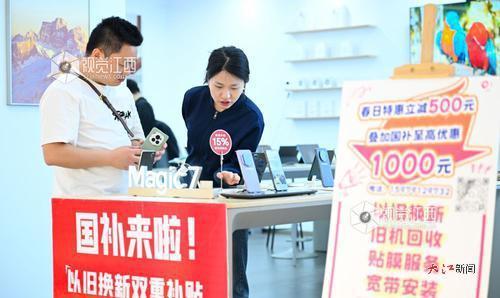 消费者在一家手机门店内咨询优惠政策，选购手机。江西日报全媒体记者张翰林摄