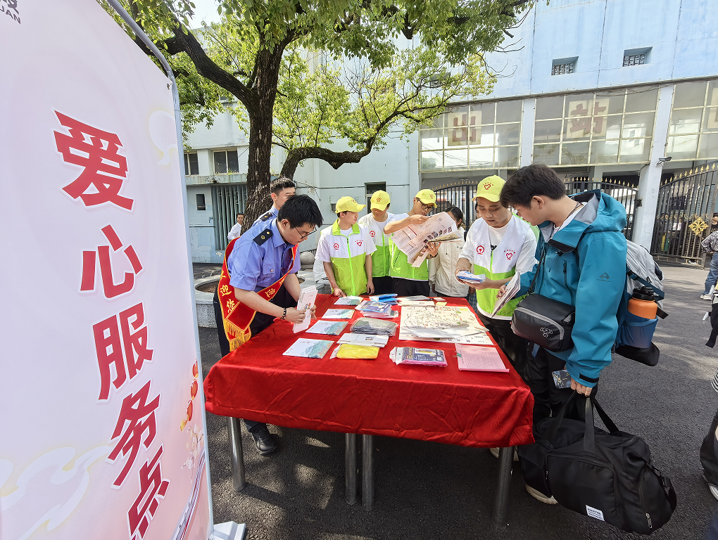 萍鄉站在出站口搭建“愛心服務點”，為登山旅客免費提供“愛心雨衣”和景區地圖。（彭元媛 攝）