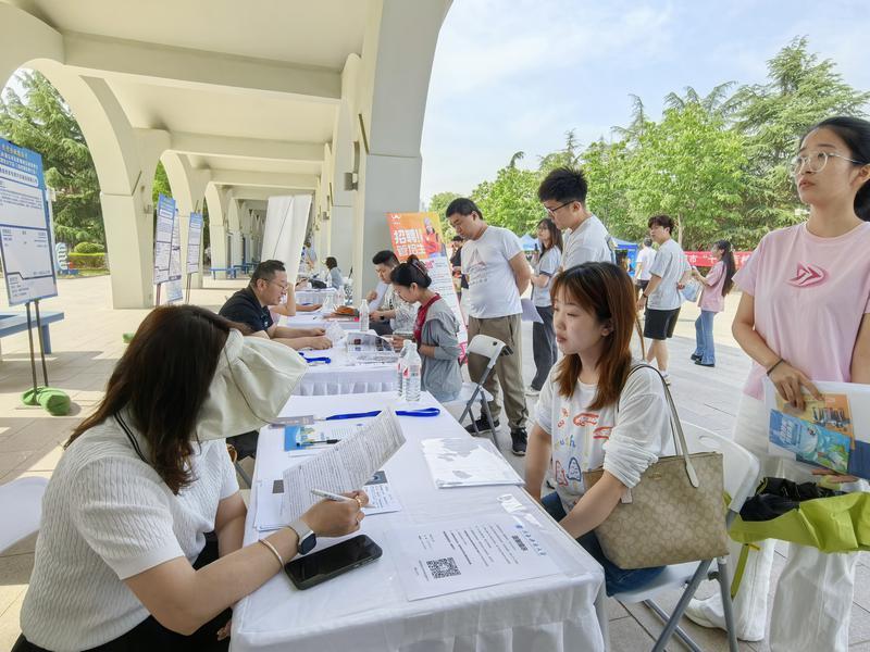 （图为招聘企业与求职者深入沟通交流中。）