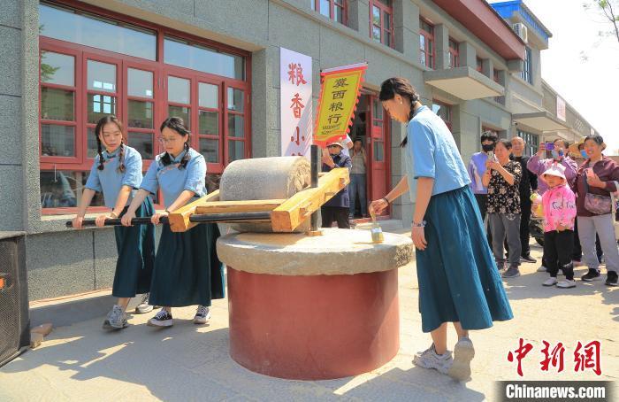 5月4日，游客在冀州老街内体验谷物研磨。　　共青团冀州区委 供图