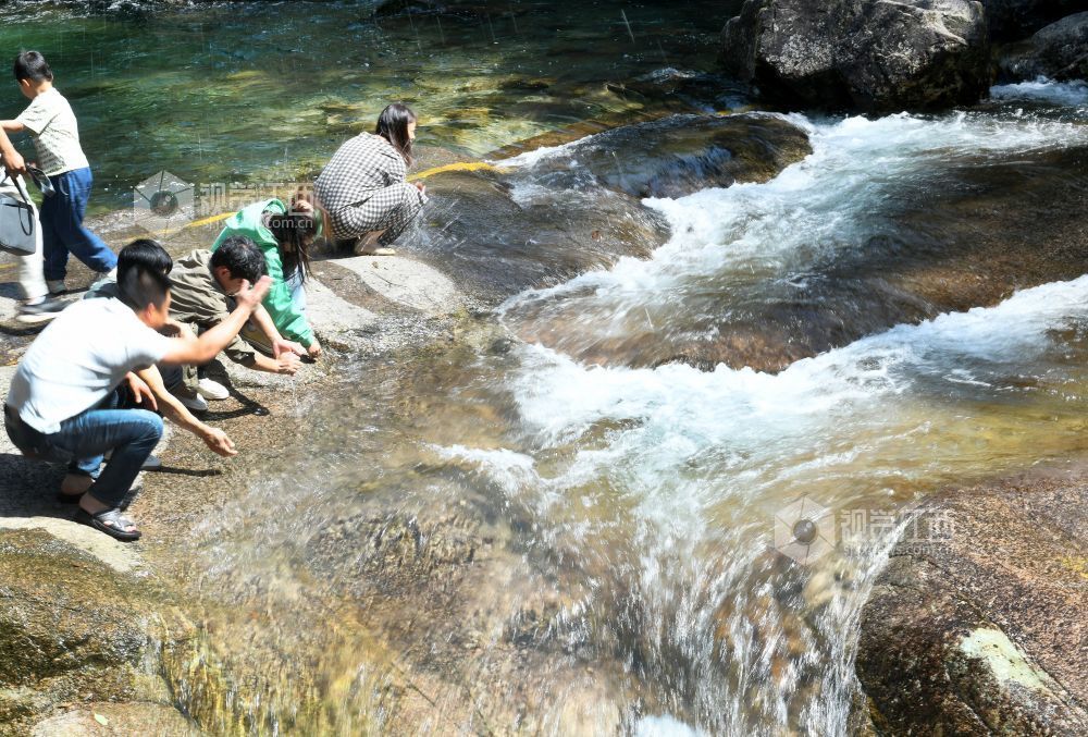 2025年5月10日，游客在江西省德兴市大茅山梧风洞景区仙女潭开心泼水嬉戏。