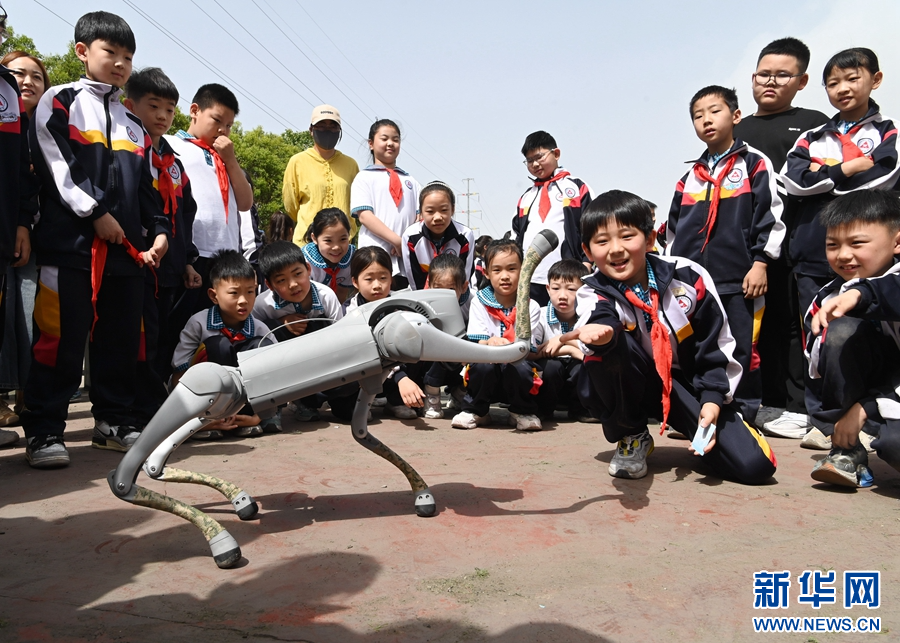 5月9日，在河南省沁阳市永威学校第五届校园科技节上，小朋友在与机器狗互动。