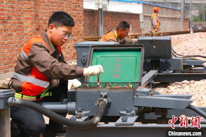 图为张凡和工友正在检修道岔转辙机。闫怀泽 摄