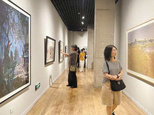 5月14日，第三届全国水粉画大展在河北科技大学铁扬美术馆开展，图为观众在欣赏展出的画作。本报记者 田 恬摄