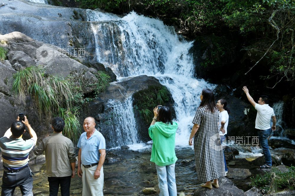 2025年5月10日，游客在江西省德兴市大茅山梧风洞景区银河飞瀑观看瀑布美景。