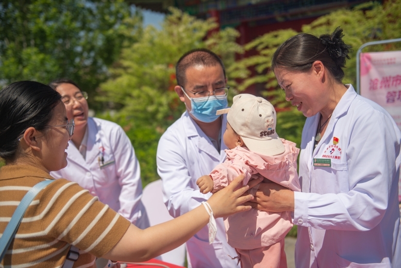 市民带着孩子向沧州市妇幼保健院的专家咨询有关问题。