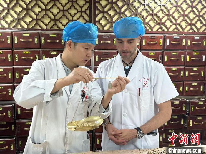 4月30日，何俊梁（右一）在甘肃中医药大学附属医院学习辨识草药。田鹏鹤　摄