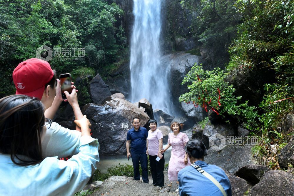 2025年5月10日，游客在江西省德兴市大茅山梧风洞景区仙女潭观看瀑布美景。