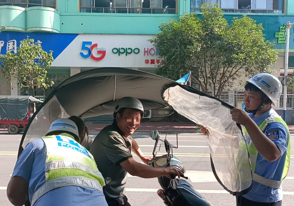 ▲宜黄交警在辖区城市道路加大对电动车、摩托车违规安装遮阳伞查处力度。