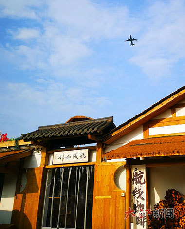 飞机掠过“航线咖啡”上空。本报全媒体记者 余燕摄