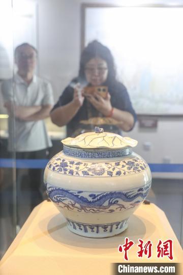 5月11日，江西宜春高安市，游客在元青花博物馆内参观展出的元青花云龙纹荷叶盖罐。元青花瓷(又称元青花)，即元代生产的青花瓷器。高安元青花博物馆是世界上第一座以元青花命名的专题性博物馆，这里珍藏了20件元代青花瓷器和4件釉里红瓷器。这些瓷器器物完整、器型硕大、品种较全、造型优美、工艺精湛，属罕见元代极品。目前，该馆馆藏元代青花瓷器数量中国第一、世界第三。中新社记者 刘力鑫 摄