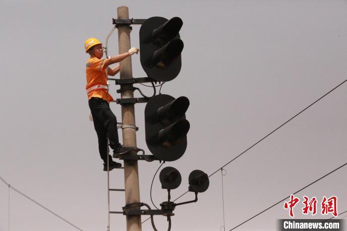 图为张凡正在检修高柱信号机。闫怀泽 摄