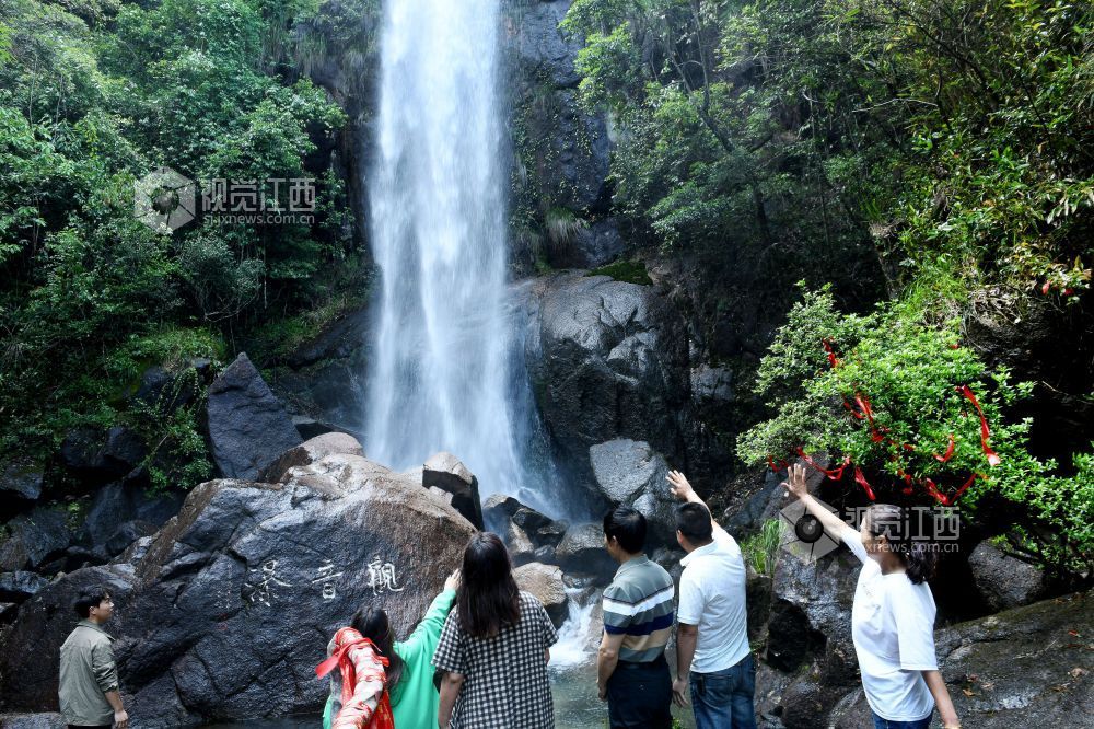 2025年5月10日，游客在江西省德兴市大茅山梧风洞景区观音瀑拍照留影。