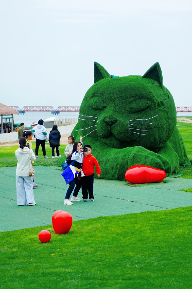 （图为阿卡猫前游客互动打卡 侯鹏摄）