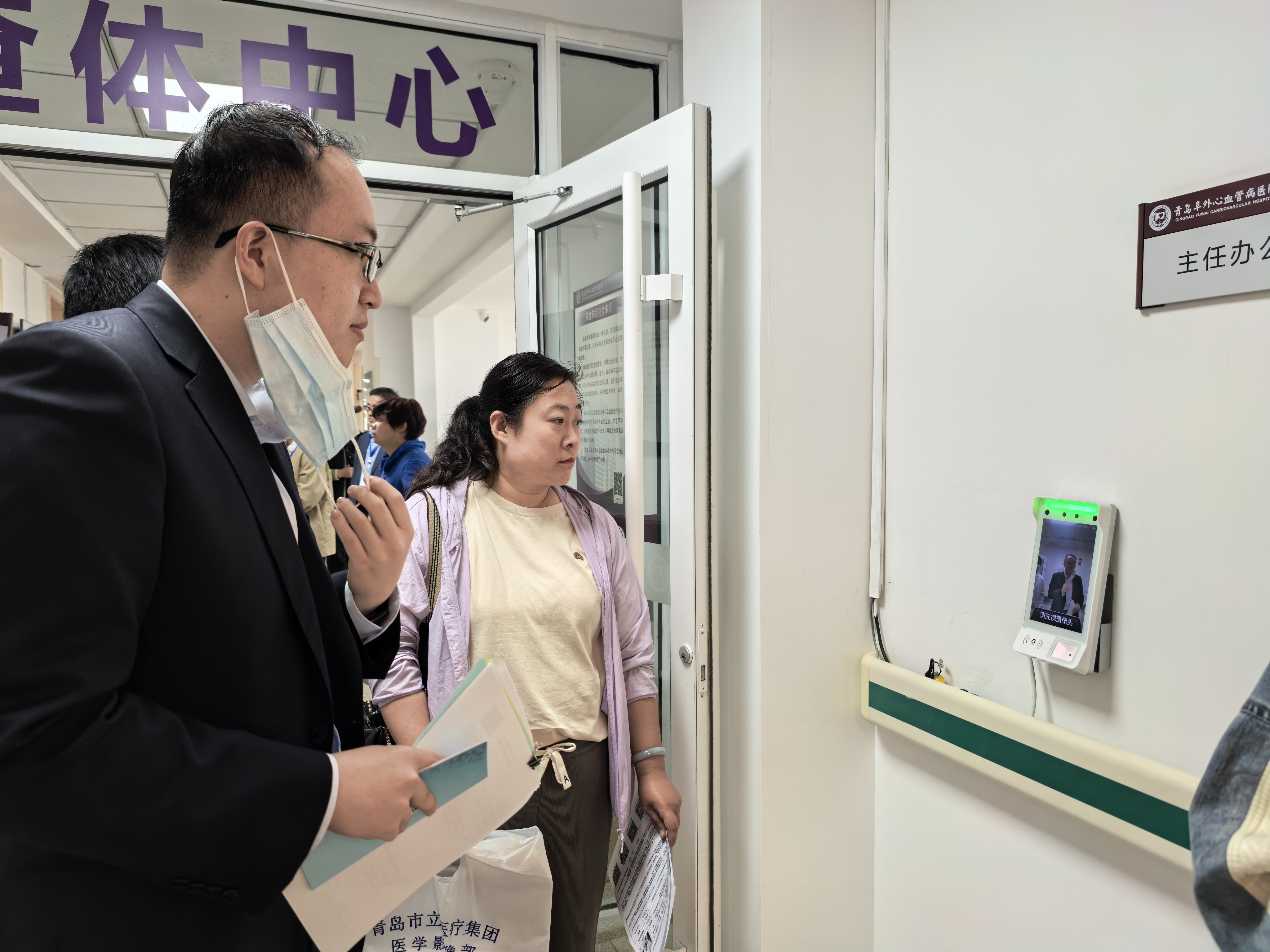 职工通过人脸识别系统验证身份进入待鉴定区