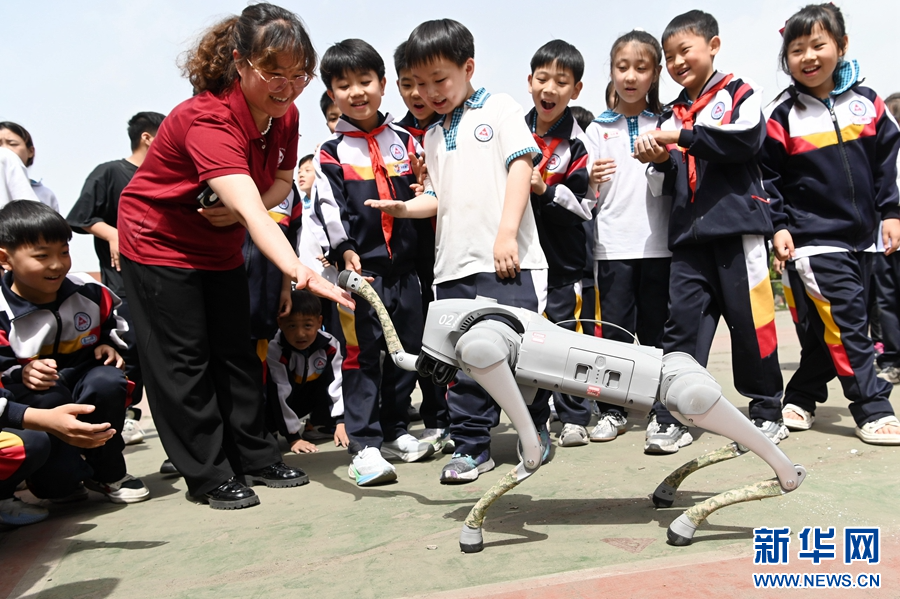 5月9日，在河南省沁阳市永威学校第五届校园科技节上，老师和同学们在与机器狗互动。